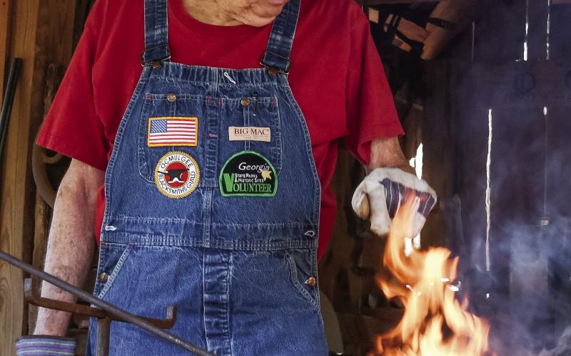 Despite being out of practice, Putnam County’s Lewis Salmon, a veteran blacksmith, was busy creating a three-legged stand at Stepback. IAN TOCHER/Staff