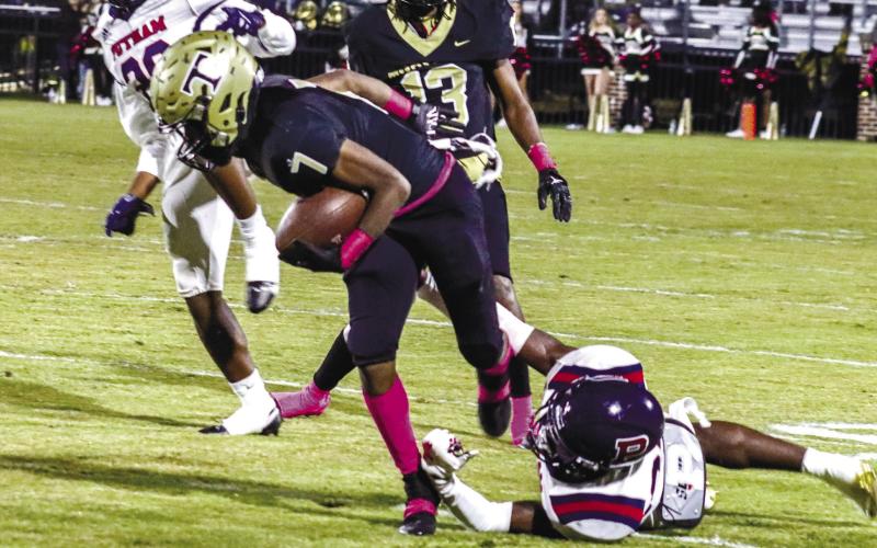 Thomson running back Jordan Lane (7) tries to break away from a Putnam defender in the Bulldogs’ 27-3 win over the War Eagles last season. LANCE McCURLEY/File photo