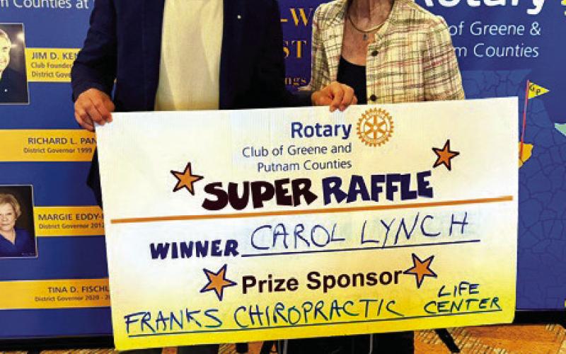 Rotarian and prize sponsor Tyler Franks (left) presents a voucher for a $300 spa/health basket sponsored by Frank’s Chiropractic Life Center to Rotary Super Raffle Week 37 winner Carol Lynch. CONTRIBUTED