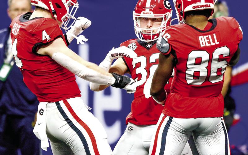 Georgia running back Cash Jones (32) celebrates with teammates Oscar Delp (4) and Dillon Bell (86) after scoring the team’s only touchdown in the third quarter of the Sugar Bowl against the Fighting Irish. LANCE McCURLEY/Staff