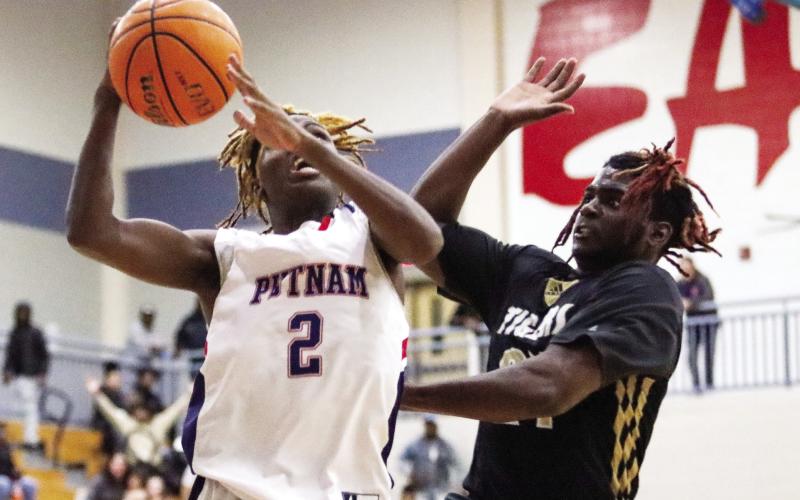 Putnam County senior guard Landon Bonner (2) goes up for a layup against Greene County junior forward RJ Monford. LANCE MCCURLEY/Staff