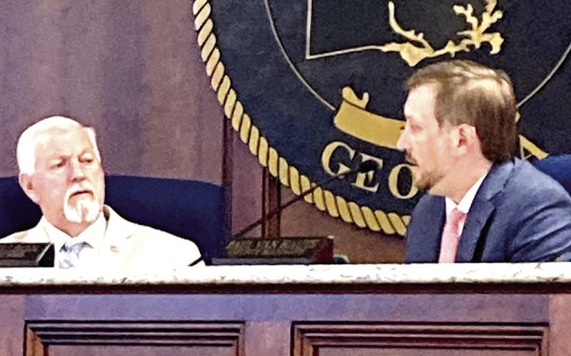 Two Putnam County commissioners discuss topics during a recent meeting. (LYNN HOBBS/Staff)