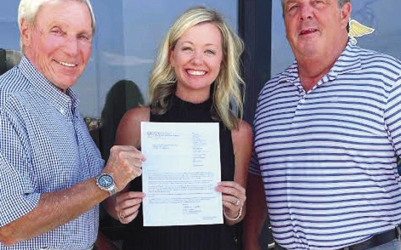 CONTRIBUTED Ralph Olson (left) and Dr. Nic Chronos, founders of Lake Country Medical Aid for Ukraine, _ank Kimberly Liebowitz of Connect and Grow with a copy of their IRS-approved, nonpro t status.