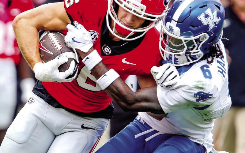 Georgia wide receiver London Humphreys (16) tries to stay in bounds while fighting off Kentucky defensive back JQ Hardaway (6). LANCE McCURLEY/Staff