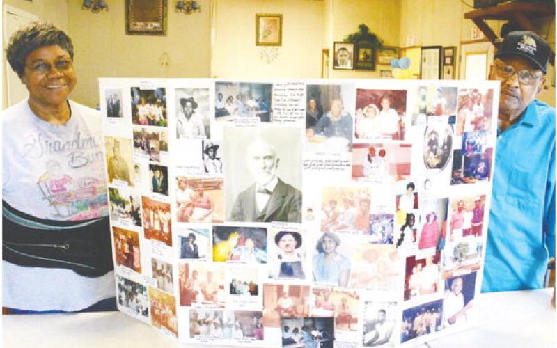 At a table inside their Kinorhook BBQ restaurant, Barbara and Frederick Ward display a “family tree” board of photos depicting relatives near and distant, going back as far as the Civil War era in Putnam County. IAN TOCHER/Staff