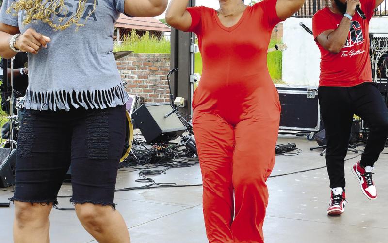 Tre Moore (right) invited a couple of dancers onstage to accompany his high-energy performance as frontman for the Savannah-based TG Live.