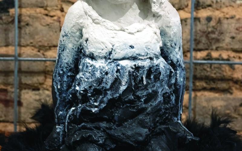 “Child of God,” sculptured by Helene Roberts is a mix of painted ceramic, feathers, and concrete. LEIGH LOFGREN/Staff