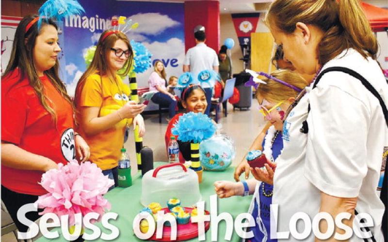 Kimberly Donovan picks a cupcake at the Farmers and Merchants Bank table as her grandma, Linda Manston, looks on.