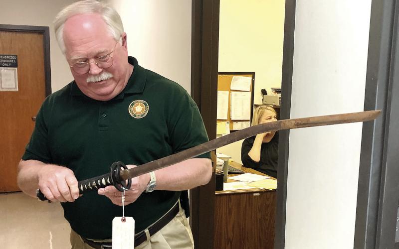Putnam County Sheriff Howard Sills shows the samurai sword that was used in a recent attack on a man and his vehicle. LYNN HOBBS/Staff