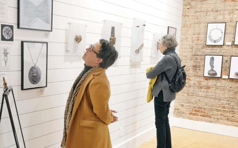Visitors look at the work of Barbara Mann featured by the Madison Artists Guild during the exhibit’s opening reception Jan. 30. LEIGH LOFGREN/Staff