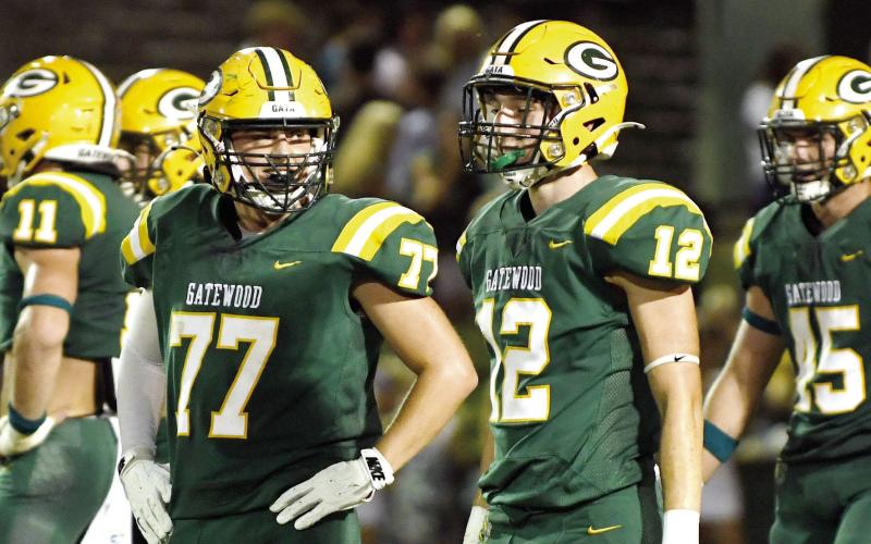 Gatewood juniors Drew Burke (77) and Sean Bennett (12) share a moment during a break in play against Augusta Prep last month at Sammons Field in Eatonton. IAN TOCHER/File photo