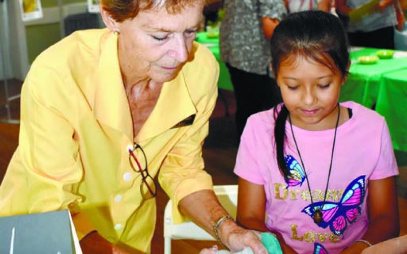 Mary Air, OSHM director of education, is helping Nataly Caballero to make a bath bomb.