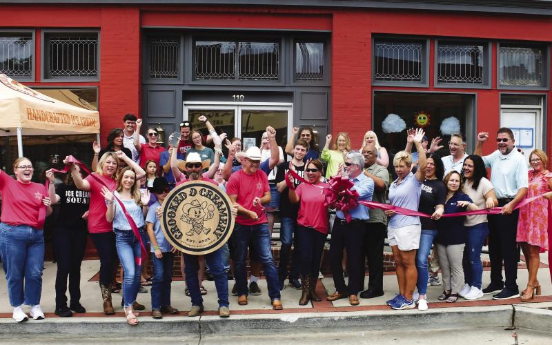 Crooked D Creamery founders and owners David Hodge (center, with scissors) and his wife, Jesse (center, sunglasses), welcomed a sizable crowd of well-wishers May 28 for their official ribbon cutting ceremony at 110 N. Jefferson Ave., in downtown Eatonton.