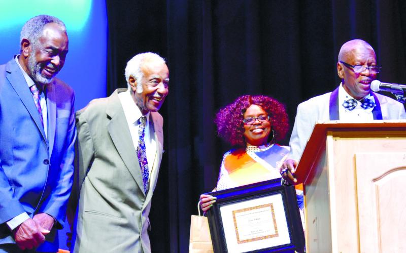 Jesse Little, right, introduces Leon (Bruce) Nelson and James Allen (Hank) Richardson Sr., who went on stage to receive their awards. LENA HENSLEY/Staff