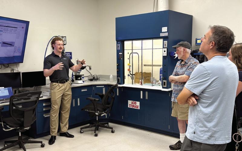 Piedmont Water lab supervisor Kyle Craig (second from left) speaks to visitors about his work in the site’s microbiology lab. SKYLA MORRIS/Staff