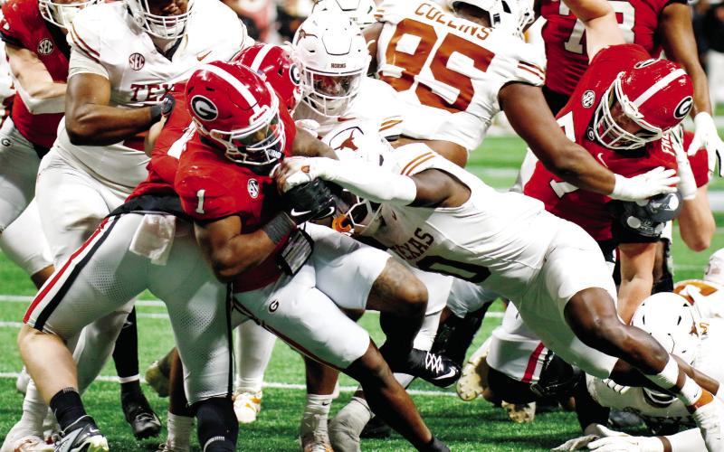Georgia running back Trevor Etienne (1) fights his way through Texas defenders to score the game-winning touchdown in overtime. LANCE McCURLEY/Staff