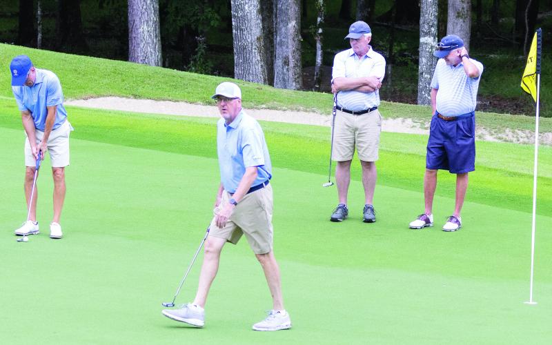Tom Clements Jr., foreground, reacts to tournament onlookers as he plays The Oconee Cup tournament during the “Alternate Shot” format on the Oconee Course. (LEIGH LOFGREN/Staff)