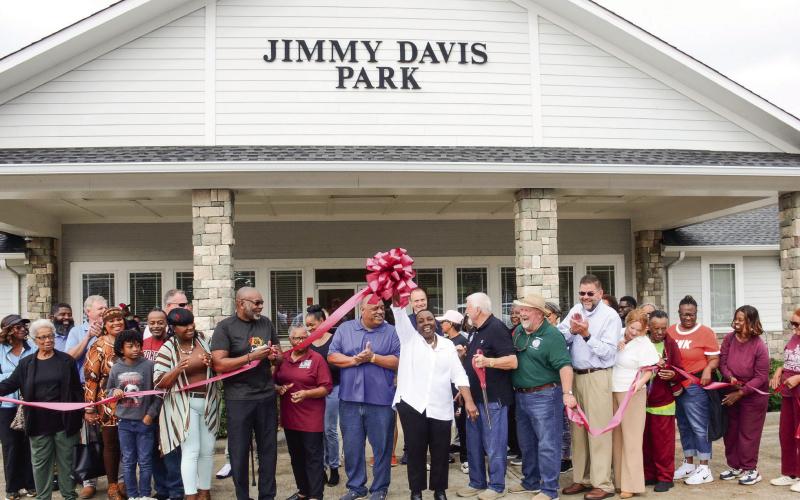 City of Eatonton Councilmember Janie Reid holds the bow high after Putnam County Chairman Bill Sharp (holding scissors beside her) cut the ribbon on Saturday to officially reopen Jimmy Davis Park, south of downtown. IAN TOCHER/Staff