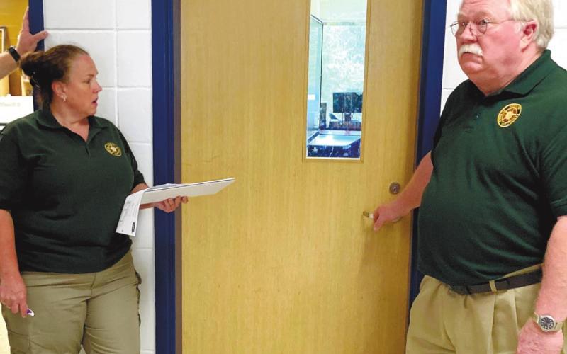 Putnam County Sheriff Howard Sills, right, listens as deputies and police officers answer his question of how to get through a locked classroom door without a key. Law enforcement toured the high school and all schools of Putnam County Charter School system Monday as they learned about and trained for school shootings. LYNN HOBBS/Staff