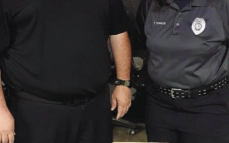 Eatonton Police Department’s officer Alex Rickey and office staff member Tammi Towles stand with the many drugs and drug paraphernalia they inventoried from a traffic stop Rickey made. CONTRIBUTED/EPD