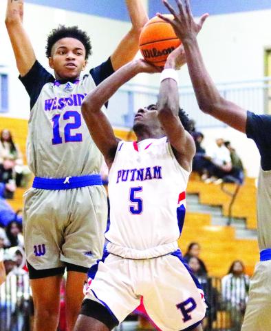 Putnam County junior Jaylin Harper (5) goes up a contested layup against a pair of Westside defenders. LANCE MCCURLEY/Staff