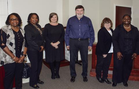 All wearing black to reflect the ink they prefer to use, members of the Putnam County Charter School System finance department (l-r) Tammy Kilgore, Nichole Crawford, Suzie Davis, Randy Pate, Judy Jones, and Coretta Harris attended Monday’s school board meeting, where they were recognized and thanked for their diligence and dedication. IAN TOCHER/Staff