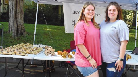 Allie Scott and her sister, Brooklyn Scott run a Beggin’ for Bones tent at the Dairy Festival. BAILEY BALLARD/Staff