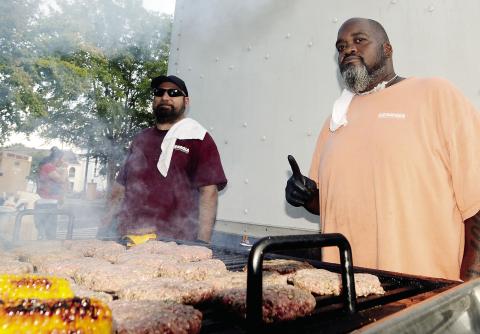 Brandon Brown (left) and Roger Bond of the Rock Eagle cafeteria crew had cheeseburgers and corn-on-the-cob on the grill at Taste of Eatonton. LEIGH LOFGREN/Staff