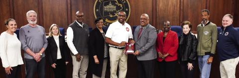 Prior to last Tuesday’s council meeting, retired Eatonton Fire Department Deputy Chief Carl Buckner, Sr. (center, white shirt) was presented with an official plaque recognizing “25 years of untiring service to the citizens of Eatonton,” by Mayor John Reid, EFD Chief Jamey Williamson, and all city council members. IAN TOCHER/Staff