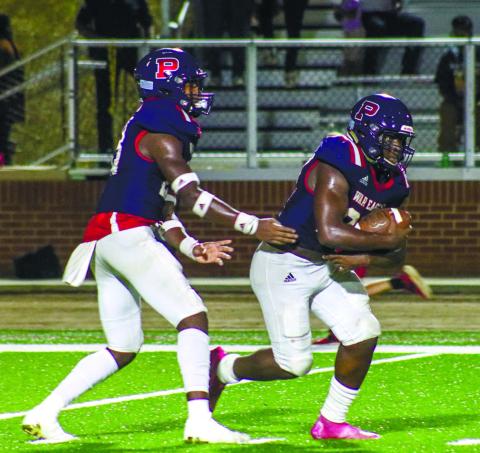 Jalon Kilgore (23) hands the ball off to Putnam County running back Tamarion Peters (27). LANCE McCURLEY/Staff