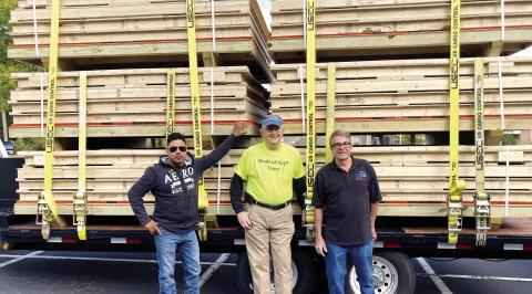 Steven Britton (right) prepares to travel to North Carolina after he and Dick Forrester (center), team coordinator of the Sheds of Hope Ministry, and lift operator Romeo Chavez help finish load the six prepackaged sheds. T. MICHAEL STONE/Staff
