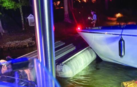 The overturned tritoon is eased to the shoreline by a Putnam County Sheriff’s patrol boat. CONTRIBUTED
