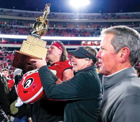 Georgia Gov. Brian Kemp (right) joins Georgia head coach Kirby Smart on the field on the field after the Bulldogs defeated Georgia Tech last season. FILE PHOTO