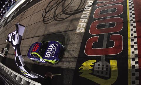 Erik Jones, driver of the #43 FOCUSfactor Chevrolet, takes the checkered flag to win the Cup Series Cook Out Southern 500 at Darlington Sunday. Jones became the first nonplayoff driver to win the first postseason event since NASCAR introduced the elimination format in 2014. (Logan Riely/Getty Images)