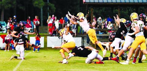 Gatewood’s Evan Bennett (7) leaps forward to successfully block a point-after-touchdown attempt by Briarwood kicker Trey Cotton. (Ball is directly behind the shoulders of Jackson Hewatt (3). DAWN SINCLAIR
