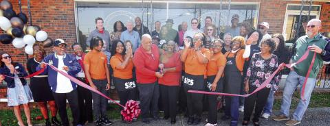 Surrounded by family and friends at high noon on Saturday, Eatonton Mayor John Reid with his wife and city councilmember Janie Reid (center), cut the ribbon to Sips, their new coffee shop and restaurant at 104 E. Marion St., in downtown Eatonton. IAN TOCHER/Staff