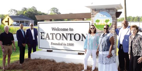 L-R: Eatonton Councilmembers Chip Walker, James Gorley, Michael Smith, Marie Rainey, Janie Reid, Mayor John Reid, and Mylle Mangum proudly show off brand-new signage heading into the city from its north side. IAN TOCHER/Staff