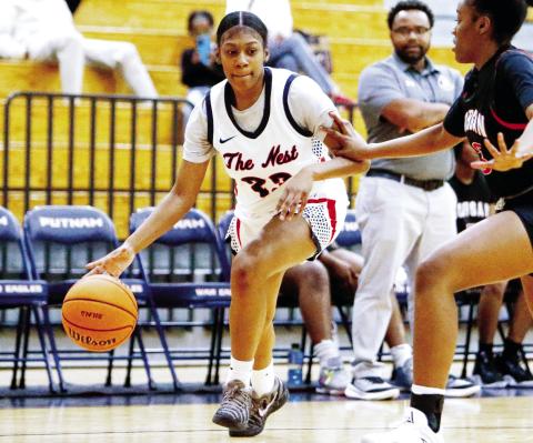 Putnam County senior forward A’ziyah Williams (23) dribbles the ball inside the key past a Morgan County defender in last week’s win over the Dogs on Nov. 22. LANCE McCURLEY/Staff