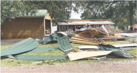 Allen Jordan used a skid steer to create a pile of the roofing materials that were scattered around his yard. LYNN HOBBS/Staff