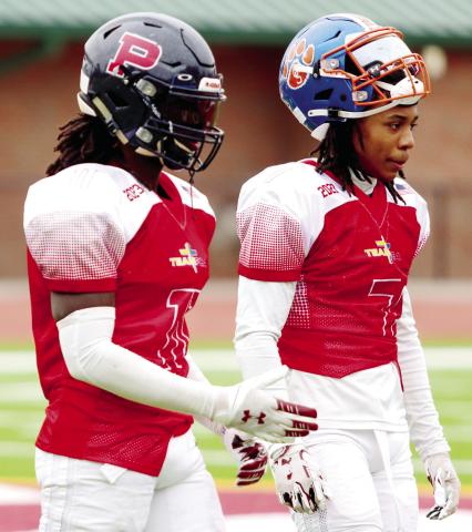 Waller (left) walks off the field during a timeout with a teammate from Cedar Shoals High School of Athens during the FCA All-Star game. LANCE MCCURLEY/Staff