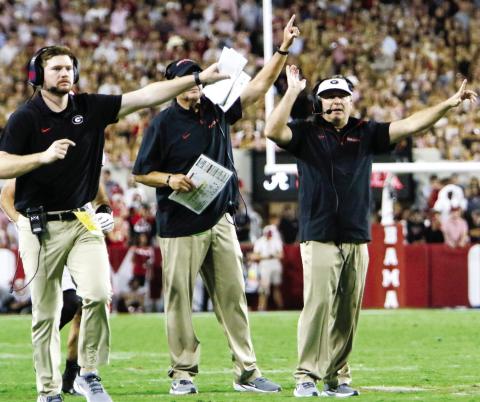 Georgia head coach Kirby Smart (far right) and members of his coaching signal their players to attempt a two-point conversion following a touchdown. LANCE McCURLEY/Staff