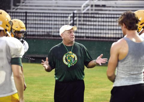 With rain soaking everyone’s shirts and jerseys, Gatewood head coach Jeff Ratliff explains his next drill during practice last Friday at Sammons Field in Eatonton. IAN TOCHER/Staff