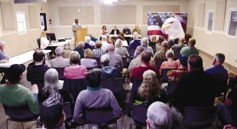 A full house faced Putnam County District 3 commissioner candidates last Thursday at Lake Oconee Lutheran Church Community Center, where former candidate Charles Trumbo (at podium) served as emcee for the event.