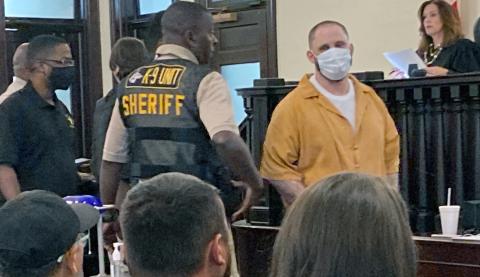 Christopher Demmon looks at and speaks to the victim’s family as he is escorted out of the courtroom.