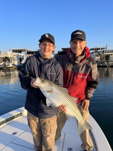 Beau and Henry Cowen with a 12-pound striper that hit topwater this past Monday morning on Lake Lanier. CONTRIBUTED