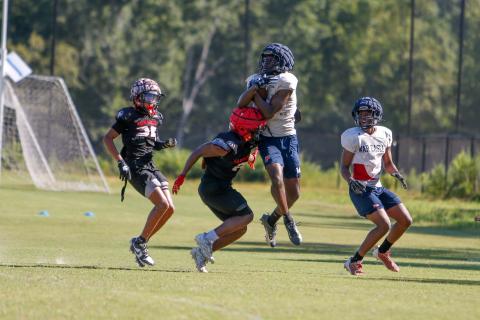 Putnam County senior wide receiver Jayson Smith (14) makes a catch in mid-air over a Winder-Barrow defender. LANCE McCURLEY/Staff