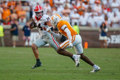 Georgia quarterback Gunner Stockton (14) scrambles out of the pocket past a Tennessee defensive back. LANCE McCURLEY/Staff