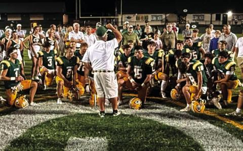 Early during the 2025 season, Gatewood head coach Jeff Ratliff (center) held court with his players, cheerleaders, and parents of both near the 50-yard line at Sammons Field in Eatonton. IAN TOCHER/Staff