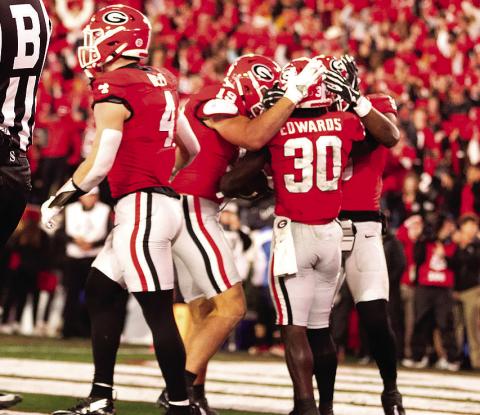 Running back Daijun Edwards (30) is congratulated by teammates after one of his rushing touchdowns. H e had two on the night. ZAK ROBINSON PHOTOGRAPHY/Contributed