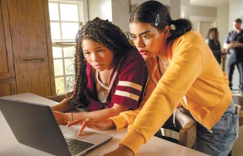 Jude, played by Storm Reid, (left) looks at Kevin’s social media with her best friend Veena, played by Megan Suri. TEMMA HANKIN/Sony Pictures